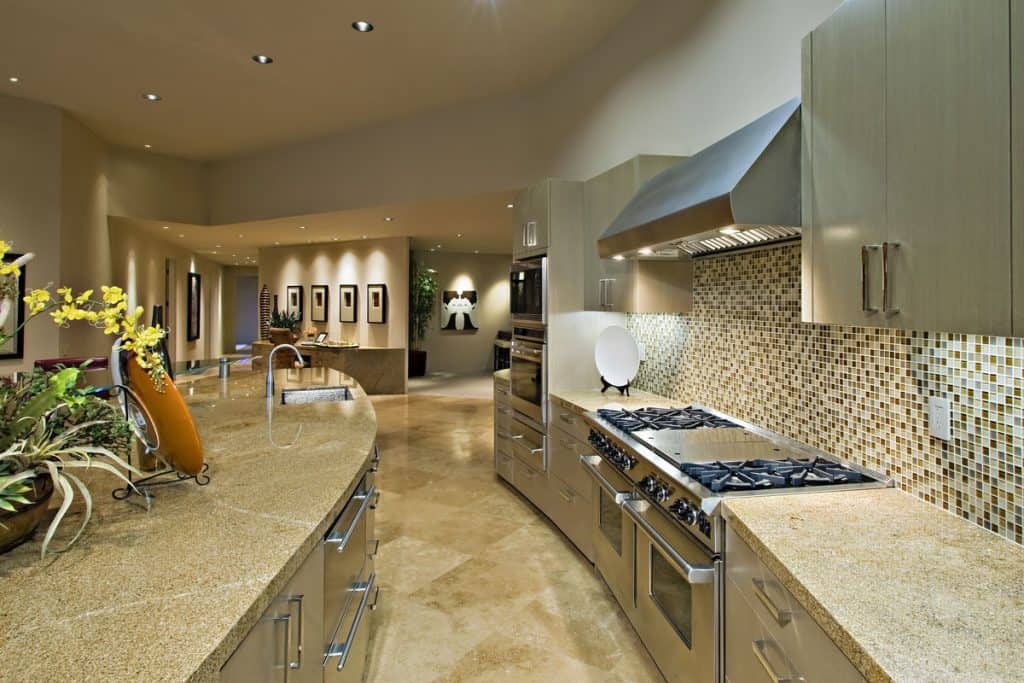 Ultra-luxurious kitchen interior with lots of recessed lighting and marble countertop