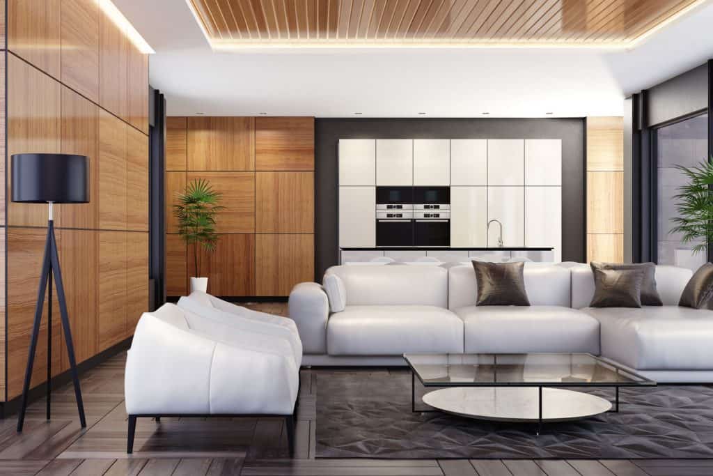 Ultra modern contemporary living room with wooden cladding and a white sectional sofa with black throw pillows