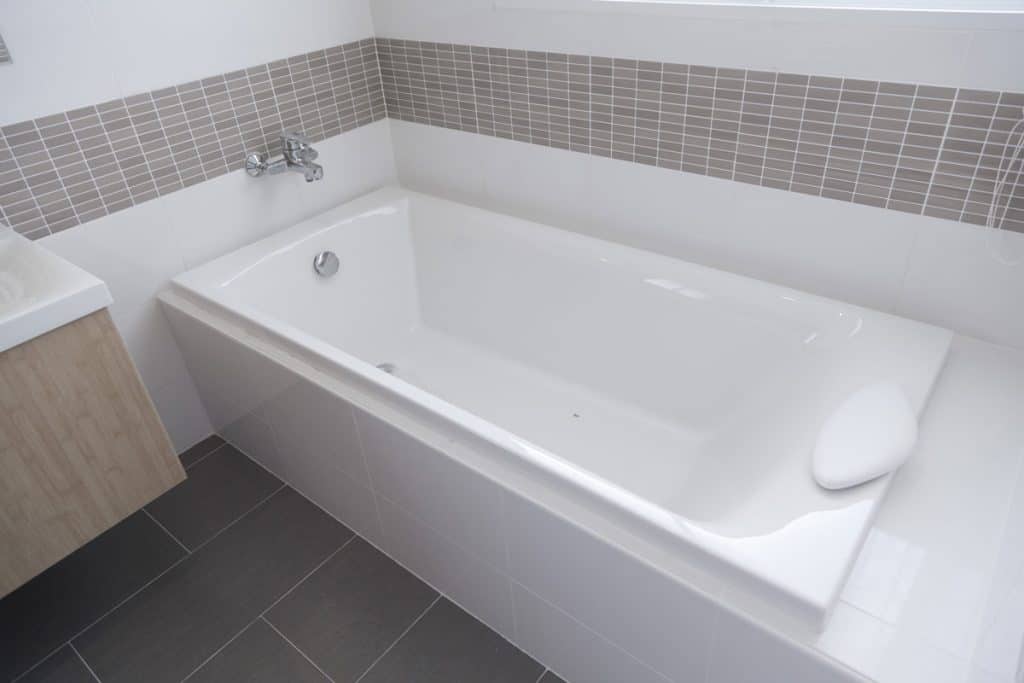 White fitted bathtub inside a modern bathroom