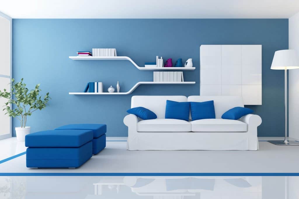 A cool blue themed living room incorporated with white and a small indoor plant near the window