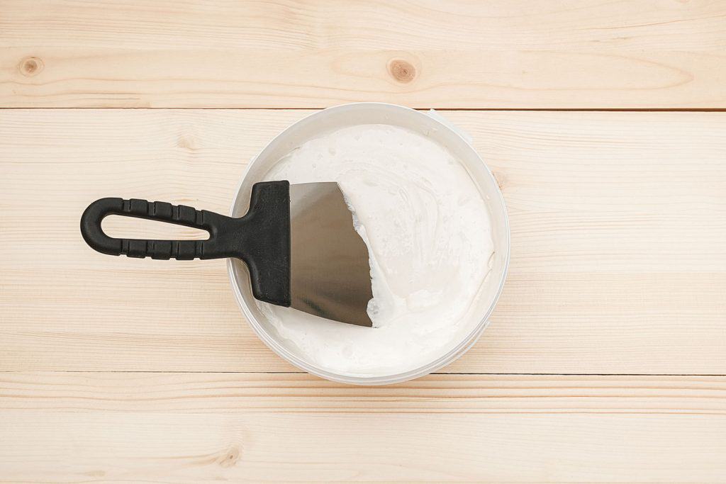 A glue with a small scooping equipment for gluing wallpaper