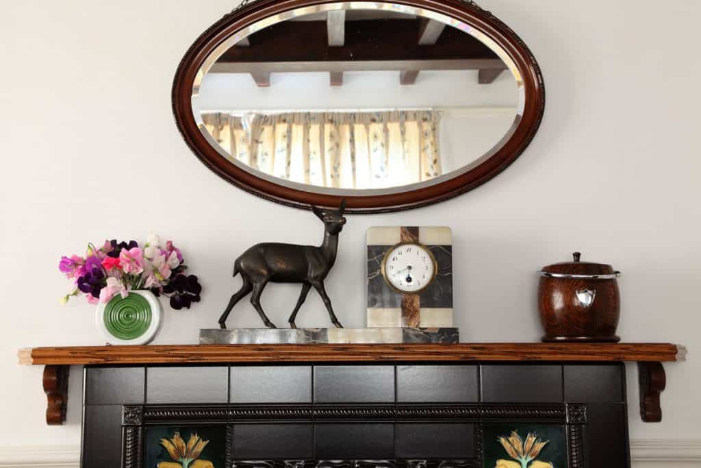 A gorgeous fireplace with black tiled mantel decorated with flowers and other figurines on top