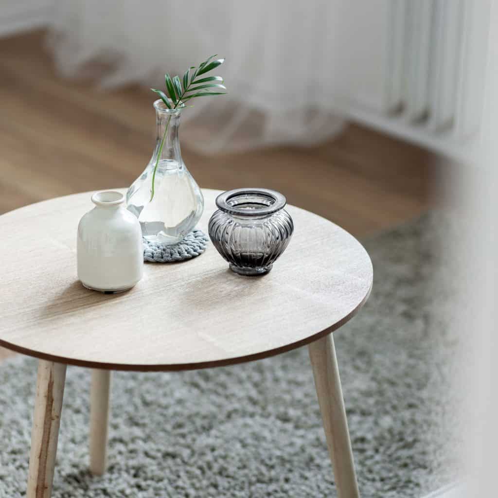 A small round coffee table decorated with vases