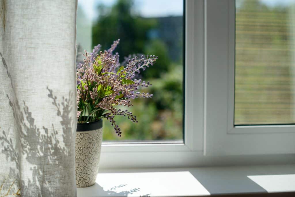 A small vase with lavender as decoration on the window sill