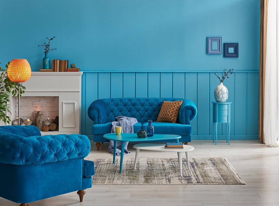 Blue wall and sofa with with orange lamp