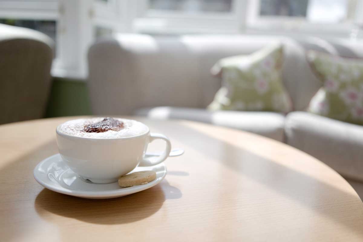 Cappuccino in a cup on a coffee table, How To Turn A Kitchen Table Into A Coffee Table