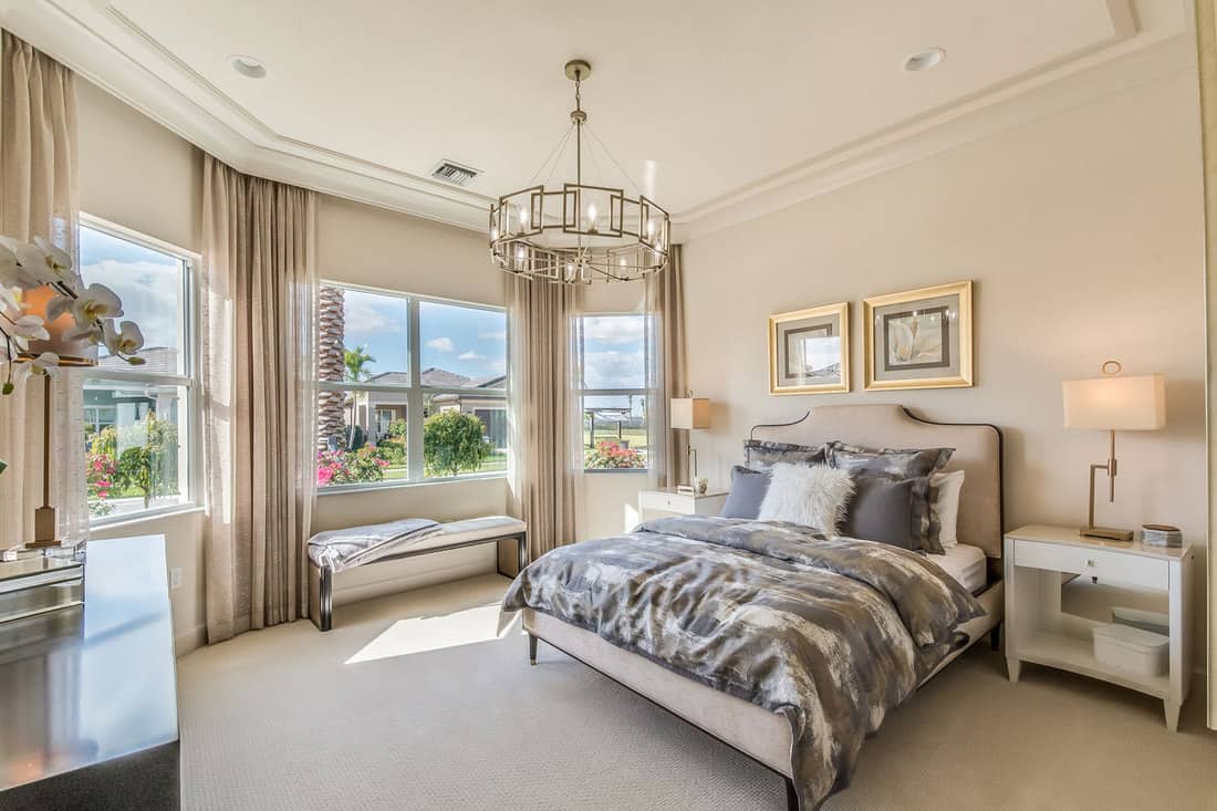 Elegant staged furnishings in master bedroom, How Big Should A Master Suite Be? [Including 11 Great Examples!]