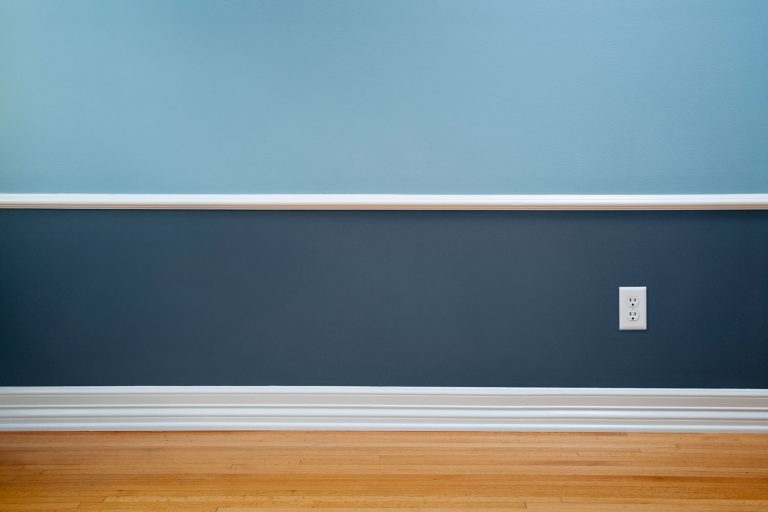 Empty room with wood flooring, blue wainscoting and a power outlet, What Color Walls Go With White Trim?