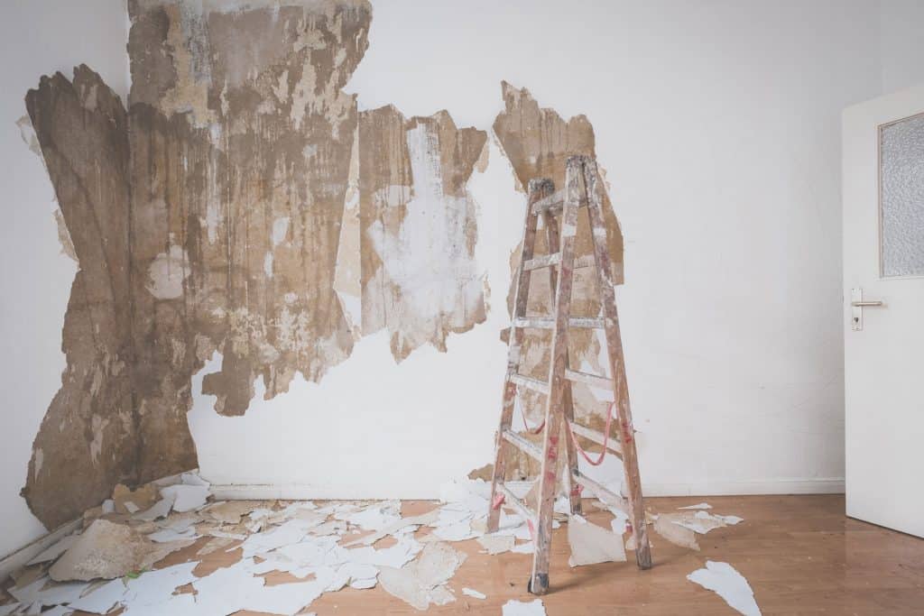 Interior of an unfinished living room scraping the walls off its white paint