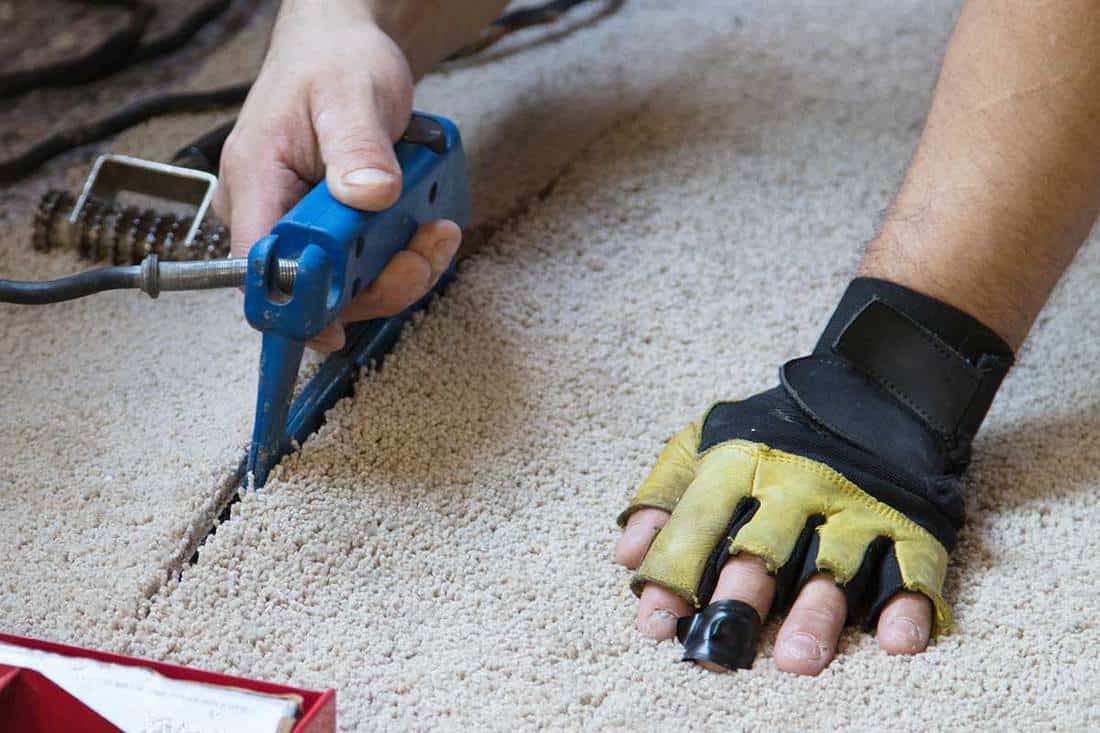 Man installing carpeting in home, How To Use A Silverline Universal Carpet Cutter