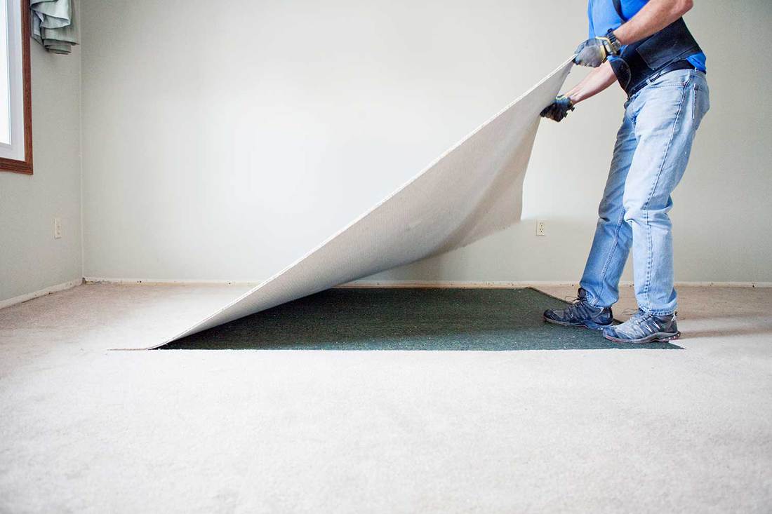 Man removing carpet during home renovations