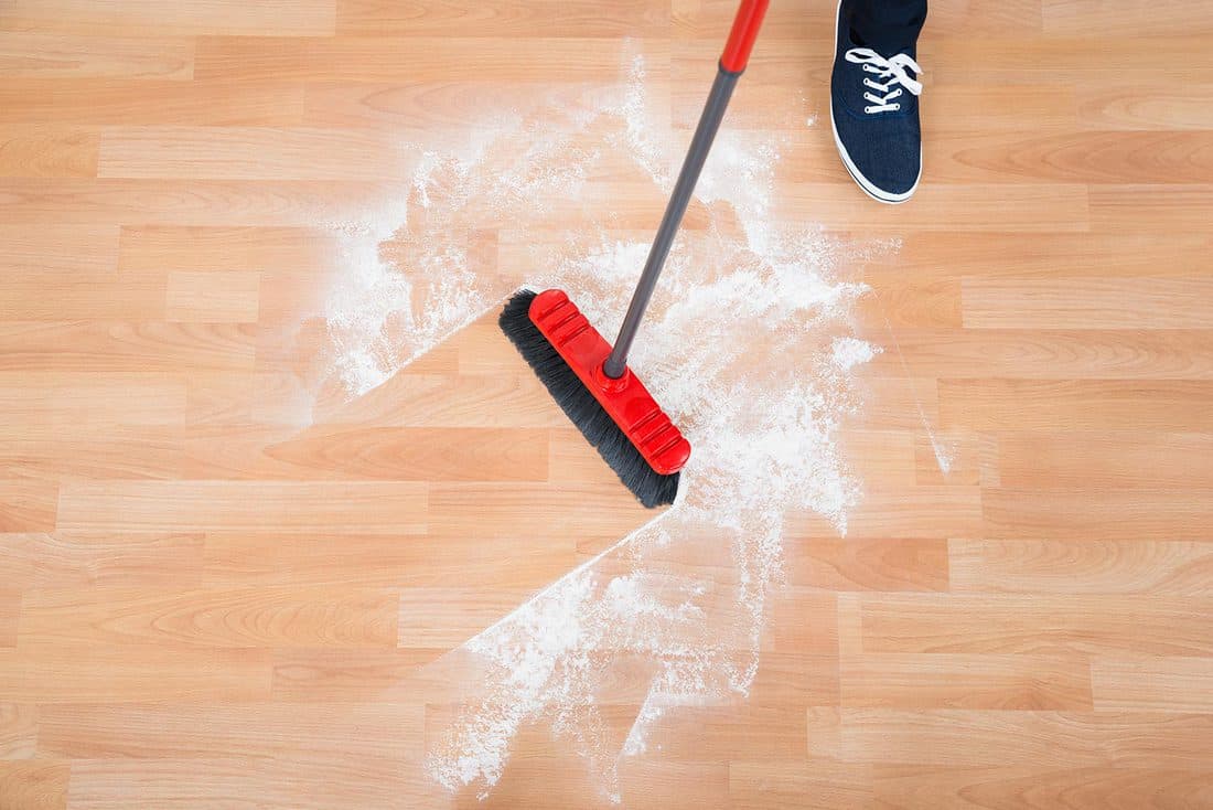 Man sweeping hardwood floor