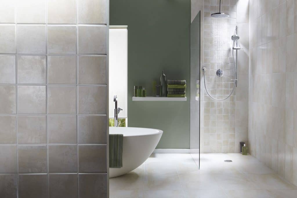 Modern contemporary bathroom with a green accent wall, glass shower wall, and gray tiled shower backsplash