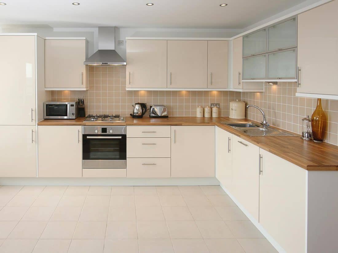 Modern kitchen interior with integrated appliances and ceramic tiled walls and floor