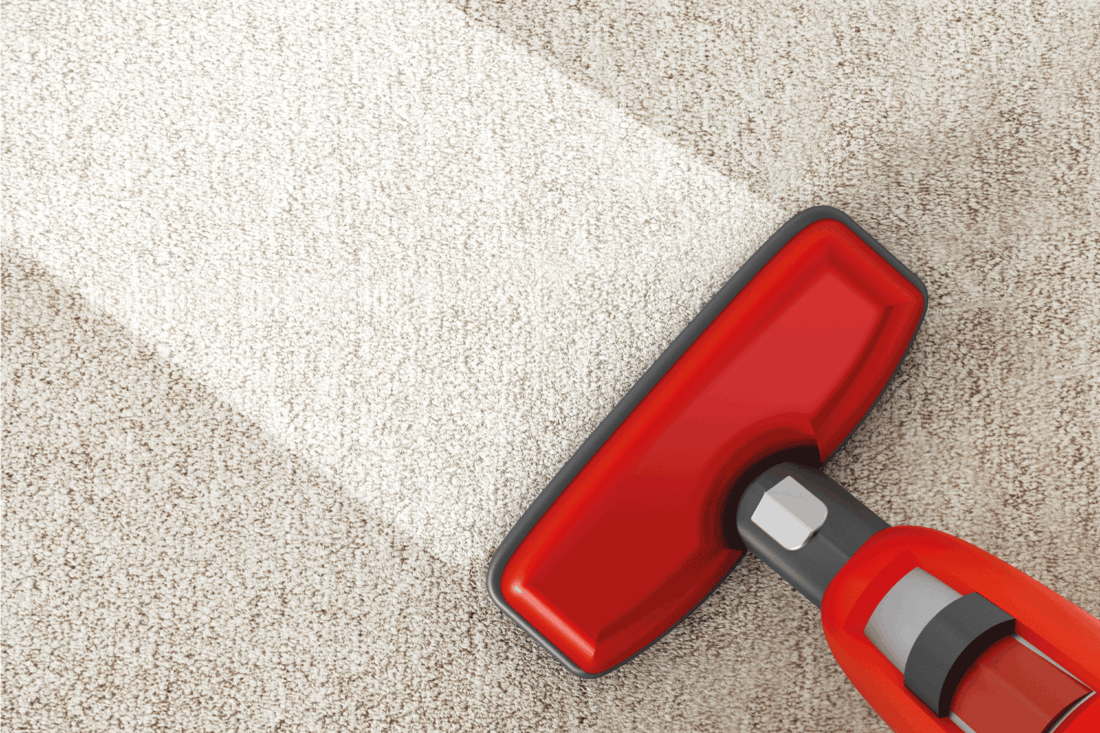 Red vacuum cleaner cleaning a carpet off of chemical carpet protector