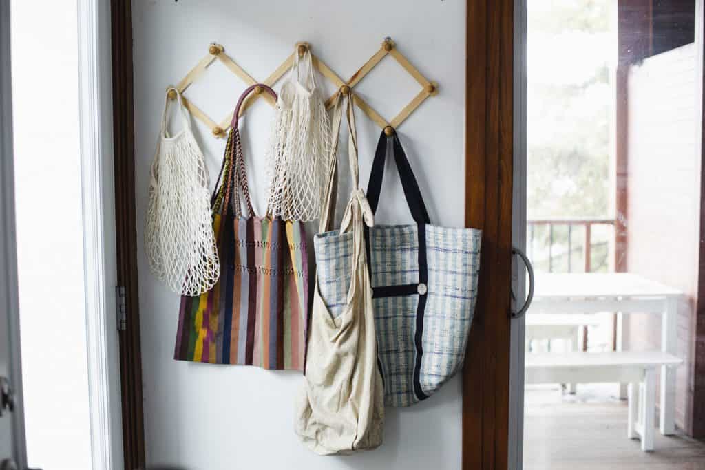 Reusable bags hanged on hooks next to the door