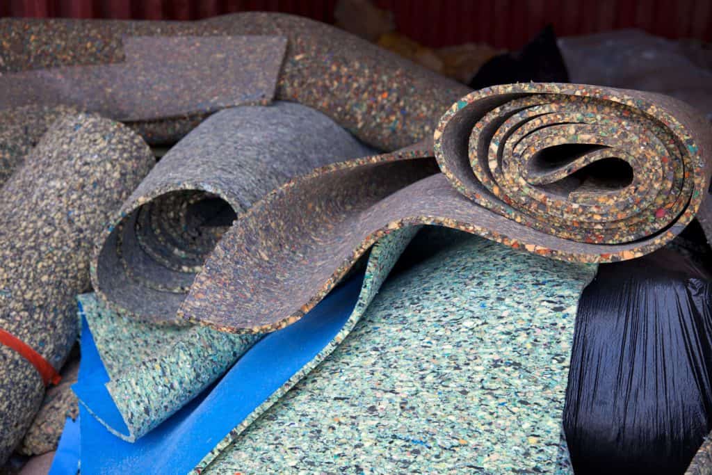 Rolled carpet padding stored in a small storage room