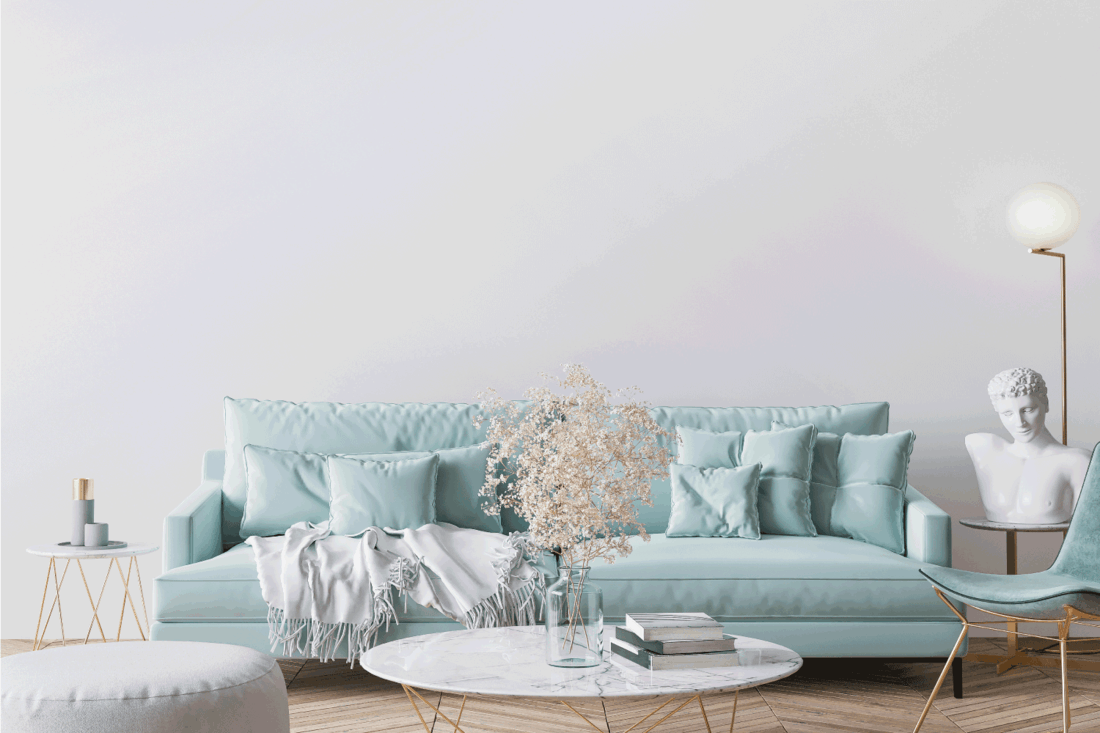 Trendy modern living room in light turquoise color and golden home accessories