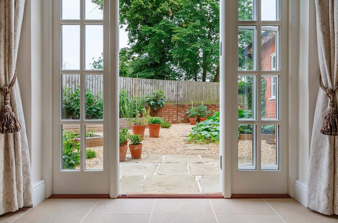 View of garden from inside house with French doors leading to a courtyard kitchen garden
