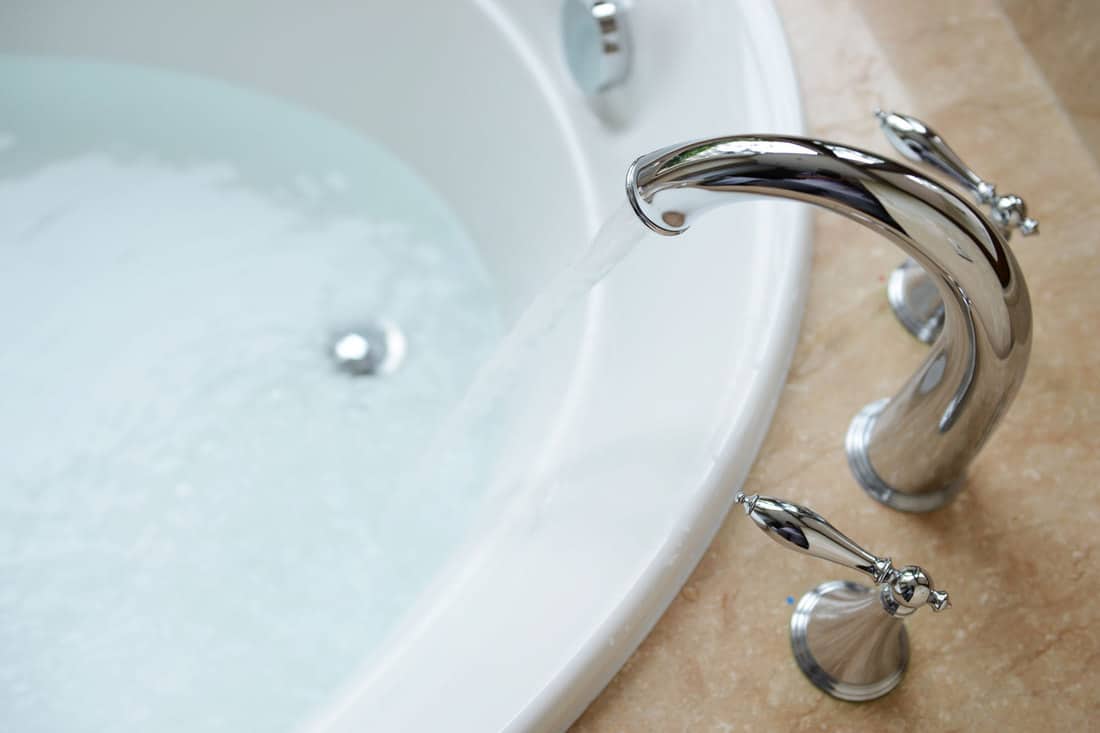 A faucet turned on inside the bathroom, How To Fix A Cracked Bathtub