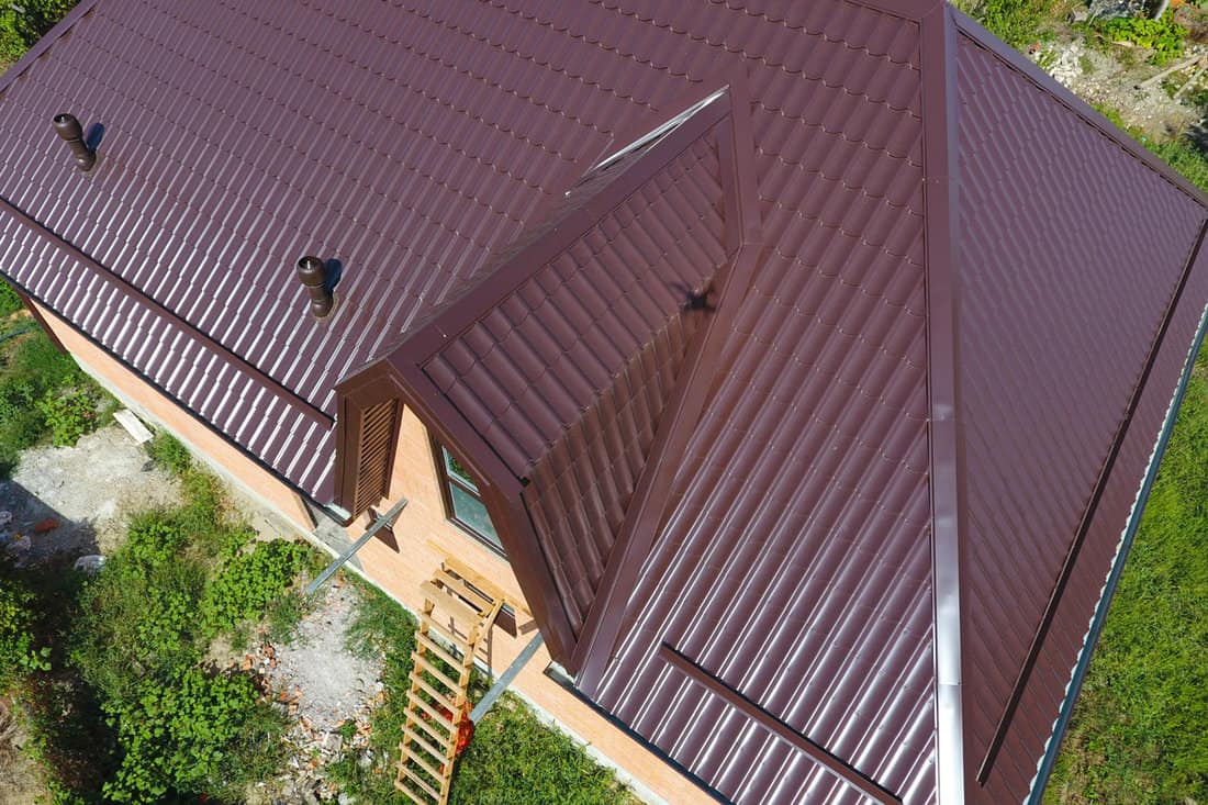 A two story house with brown metal roofing