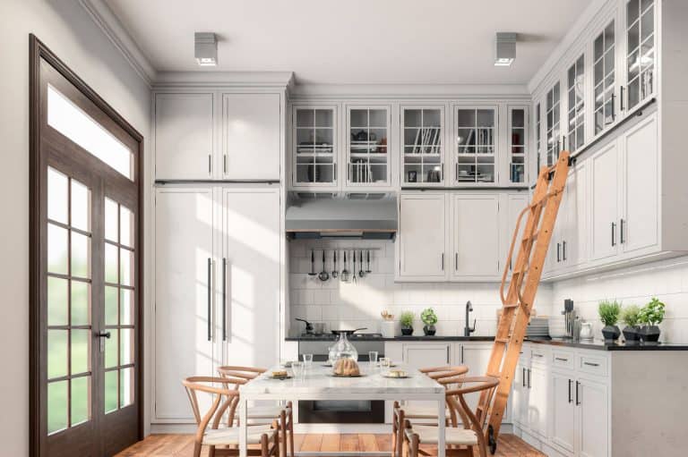 Empty classic kitchen with high cabinets, table, chairs, ladder and decoration with classic windows on the left, How Much Space Between Countertop And Upper Cabinets?