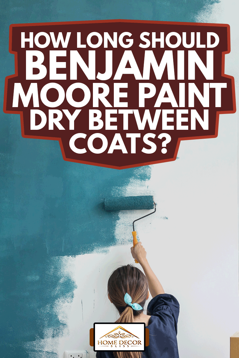 Young asian happy woman painting interior wall with paint roller in new house, How Long Should Benjamin Moore Paint Dry Between Coats?