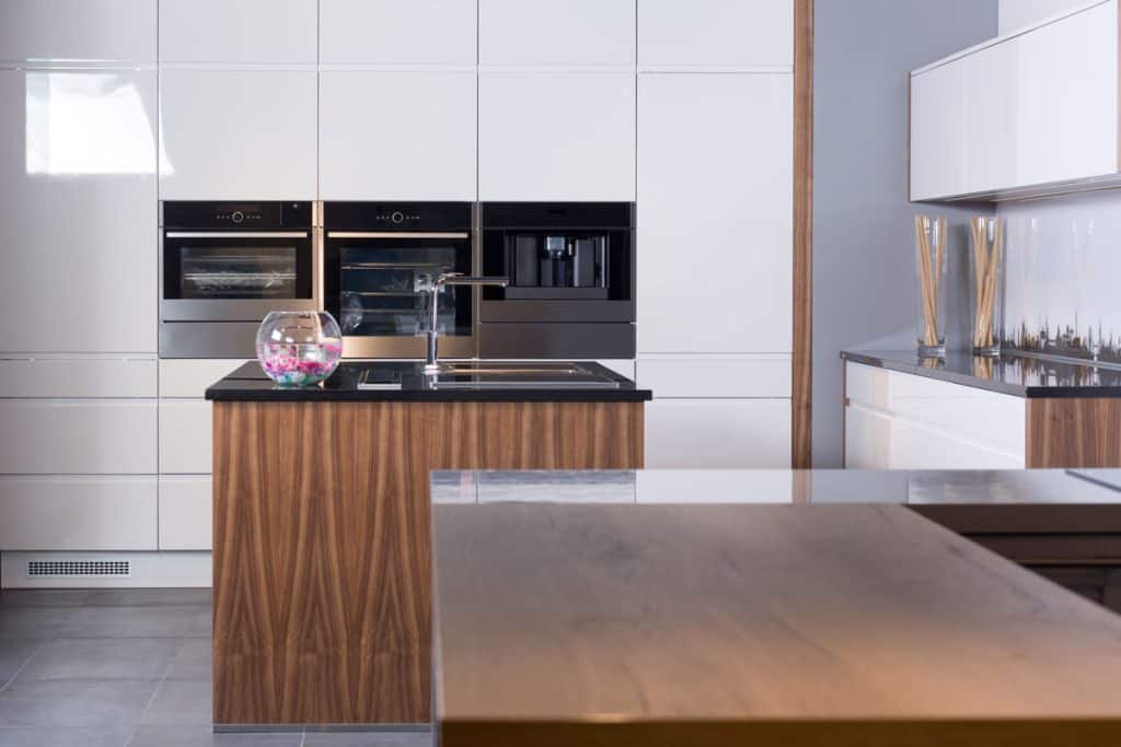 Interior of ultra-modern kitchen with stainless appliances and wooden brown countertop