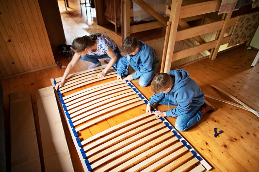 Mother and her two kids setting up bedslats