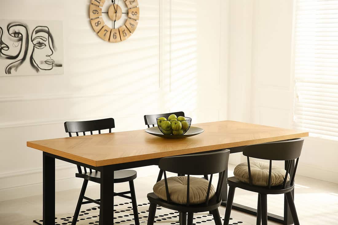 Stylish wooden dining table and chairs in room