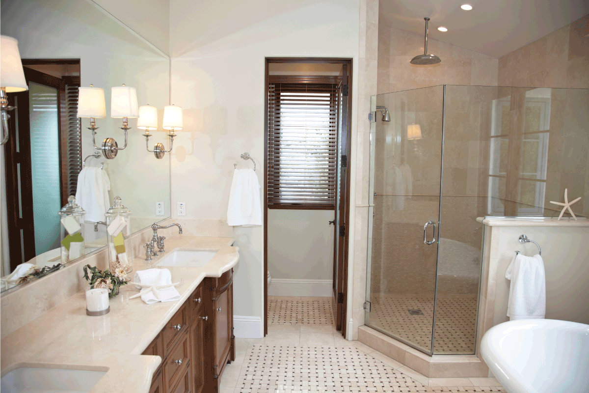 bright bathroom with sconce lighting, brown accents, glass shower area. What Is The Best Color Temperature For Bathroom Lighting