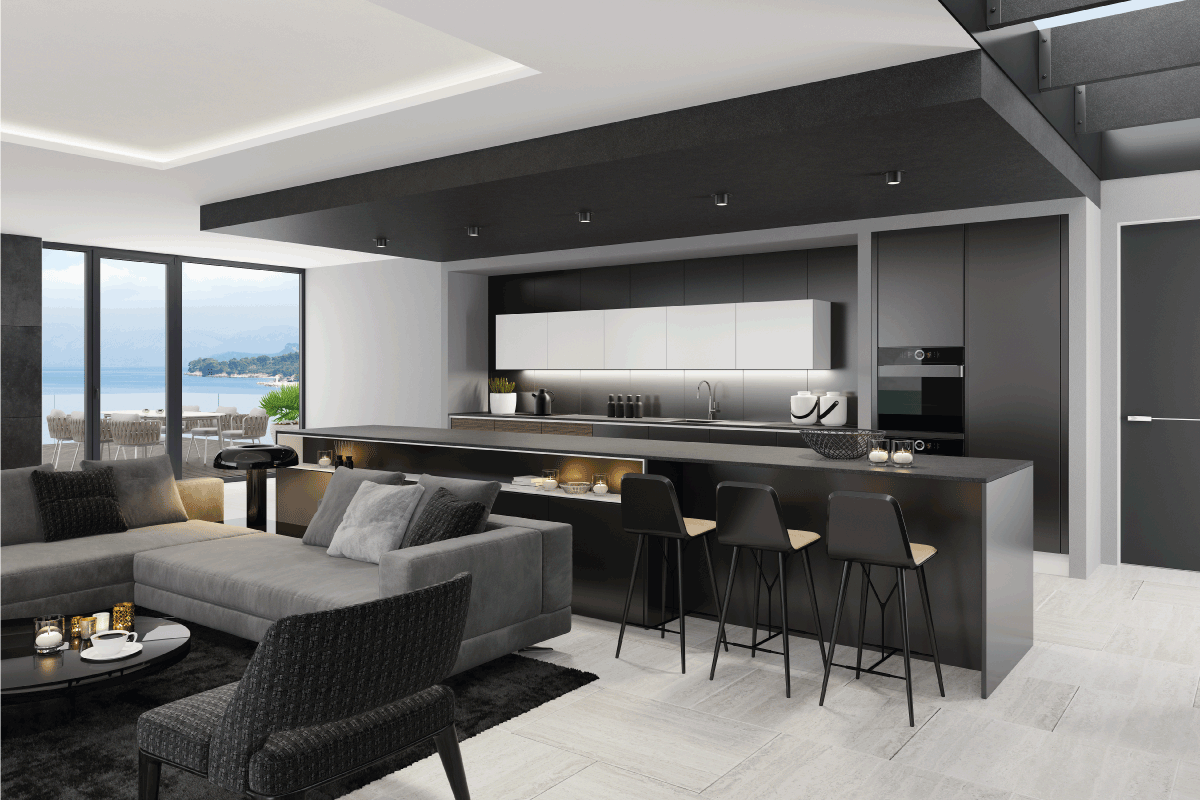 living room interior and modern minimalist kitchen with big kitchen island and three stools. Matte black cabinets. Black carpet. Grey sofa with armchairs. What Color Walls Go With Black Ceiling
