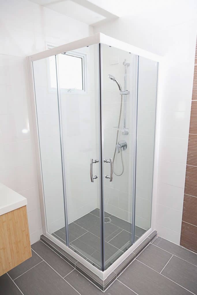 A small shower area with glass shower wall
