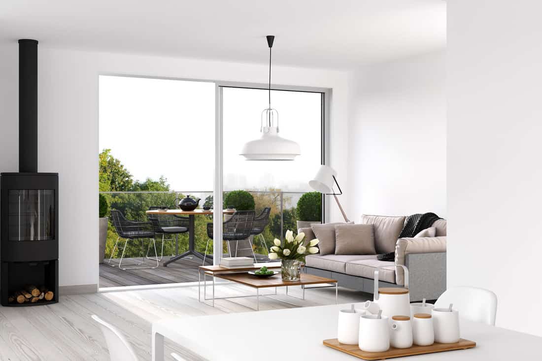 Interior of a modern white painted living room with a huge sliding door leading to a balcony, Which Way Should A Sliding Door Open?