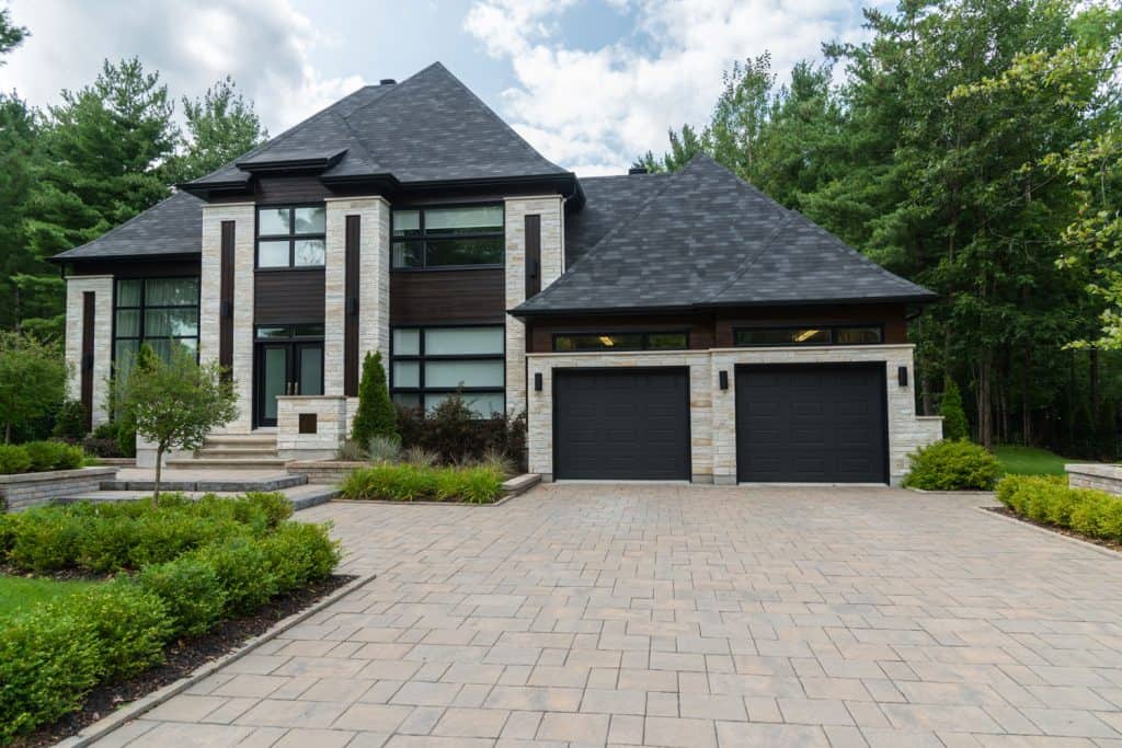 Exterior of a luxurious modern dream contemporary house with asphalt roofing, huge windows and a huge driveway