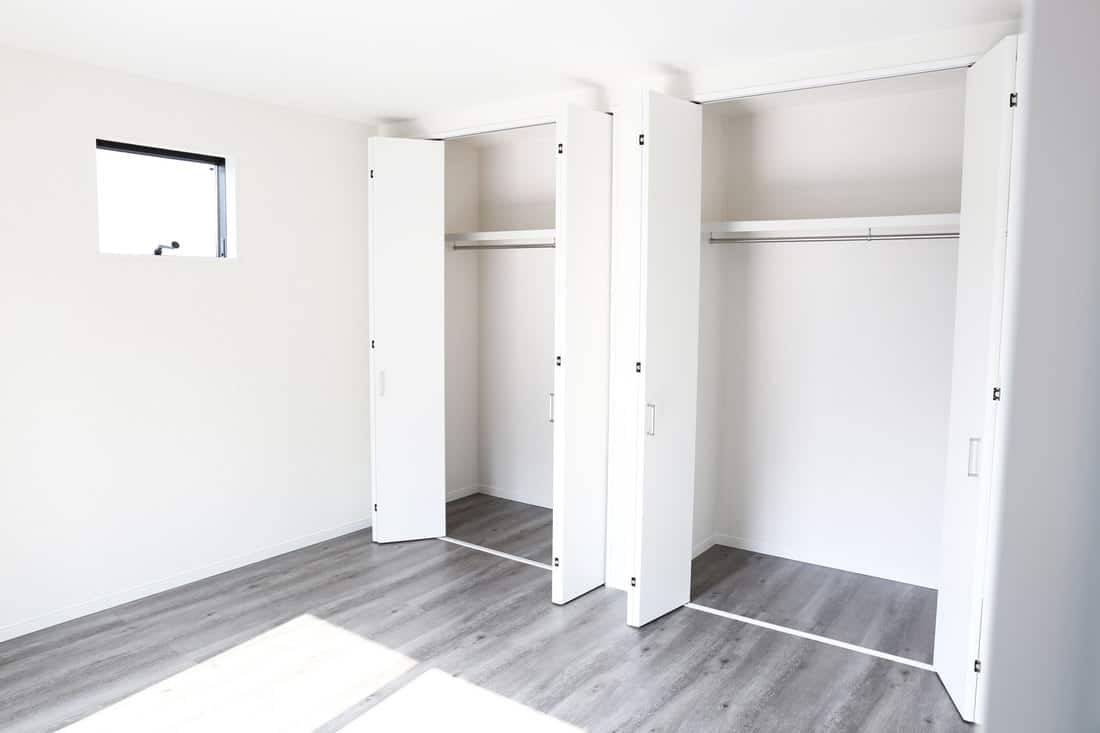 Interior of a white living bedroom with white closet doors and light gray vinyl flooring, What Color Closet Doors Go With White Walls?