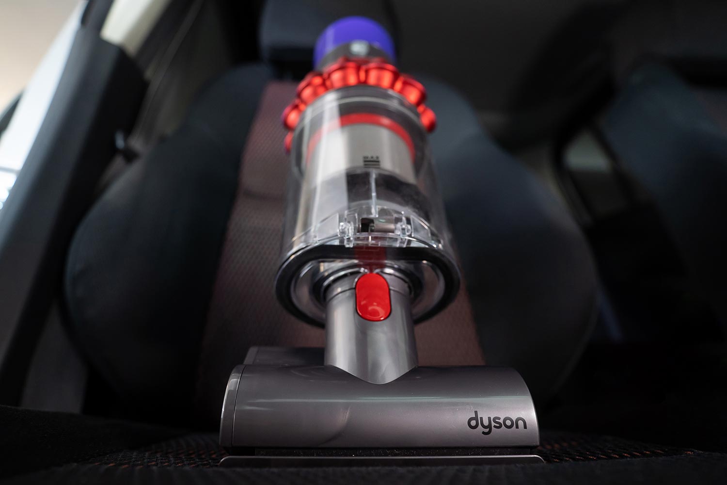 Mini motorhead of Dyson Cyclone V10 Fluffy vacuum cleaner on car seats with car