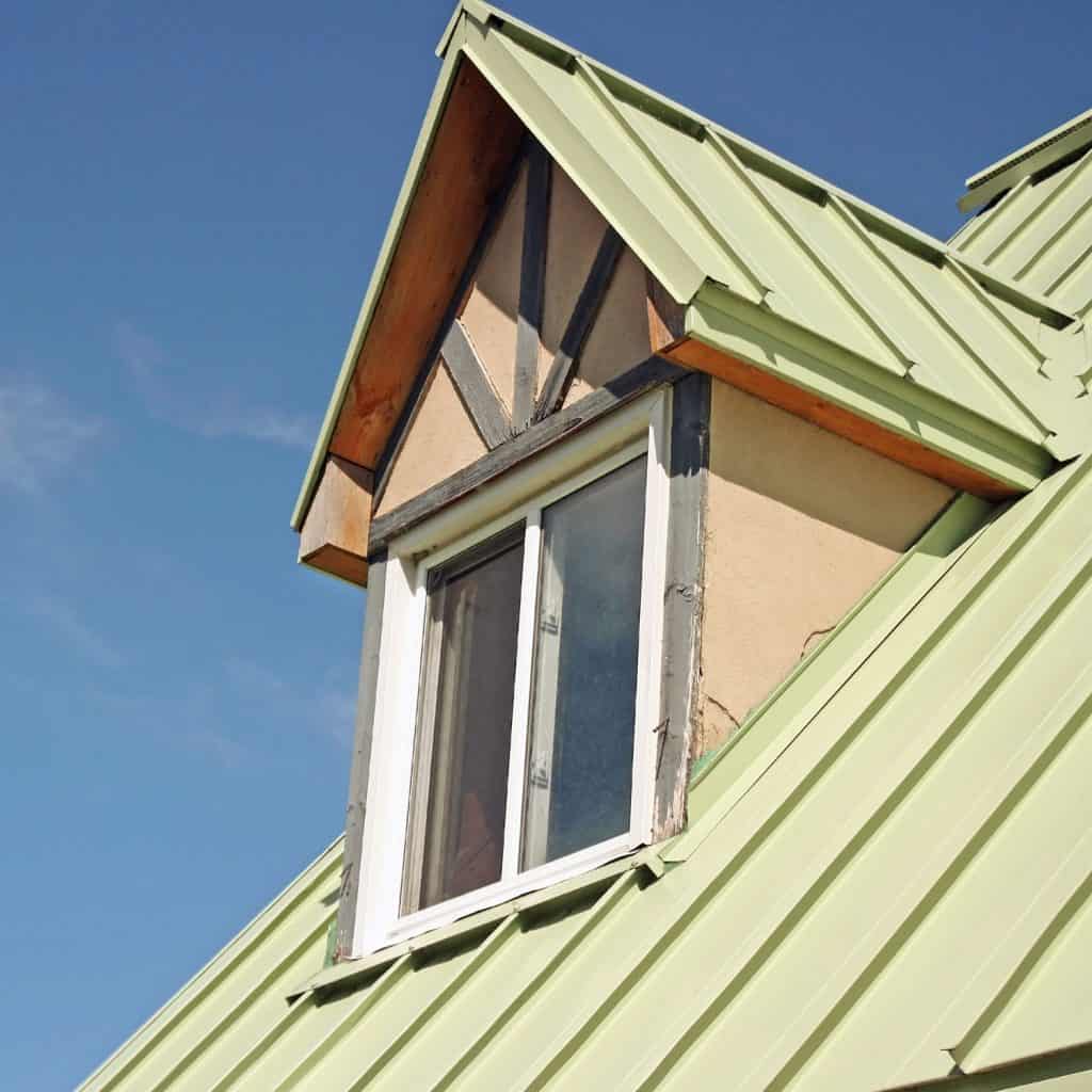 Minth green colored roof with wooden siding on the dormer