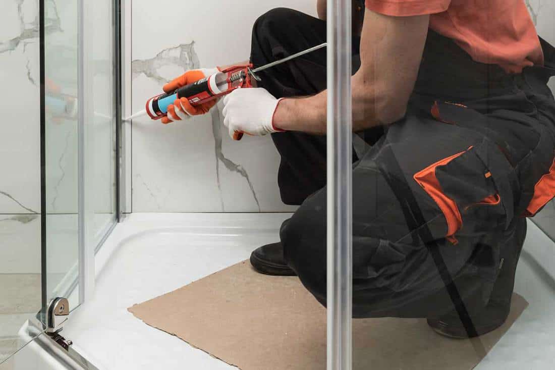 Sealing the shower enclosure with silicone to prevent leakage