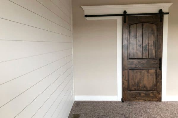 A small barn door made form hardwood planks, Should A Sliding Barn Door Cover Trim?