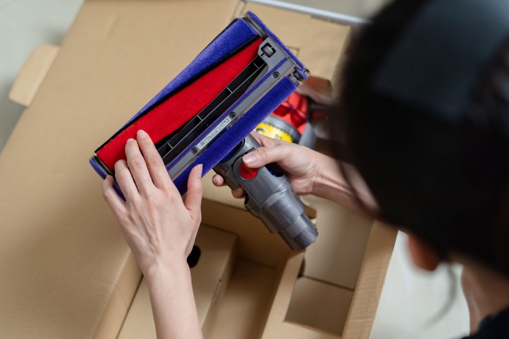 A woman assembling the parts of a Dyson cordless vacuum cleaner