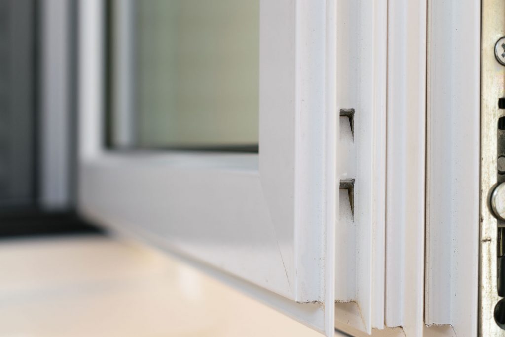 An up close photo of a white framed casement window