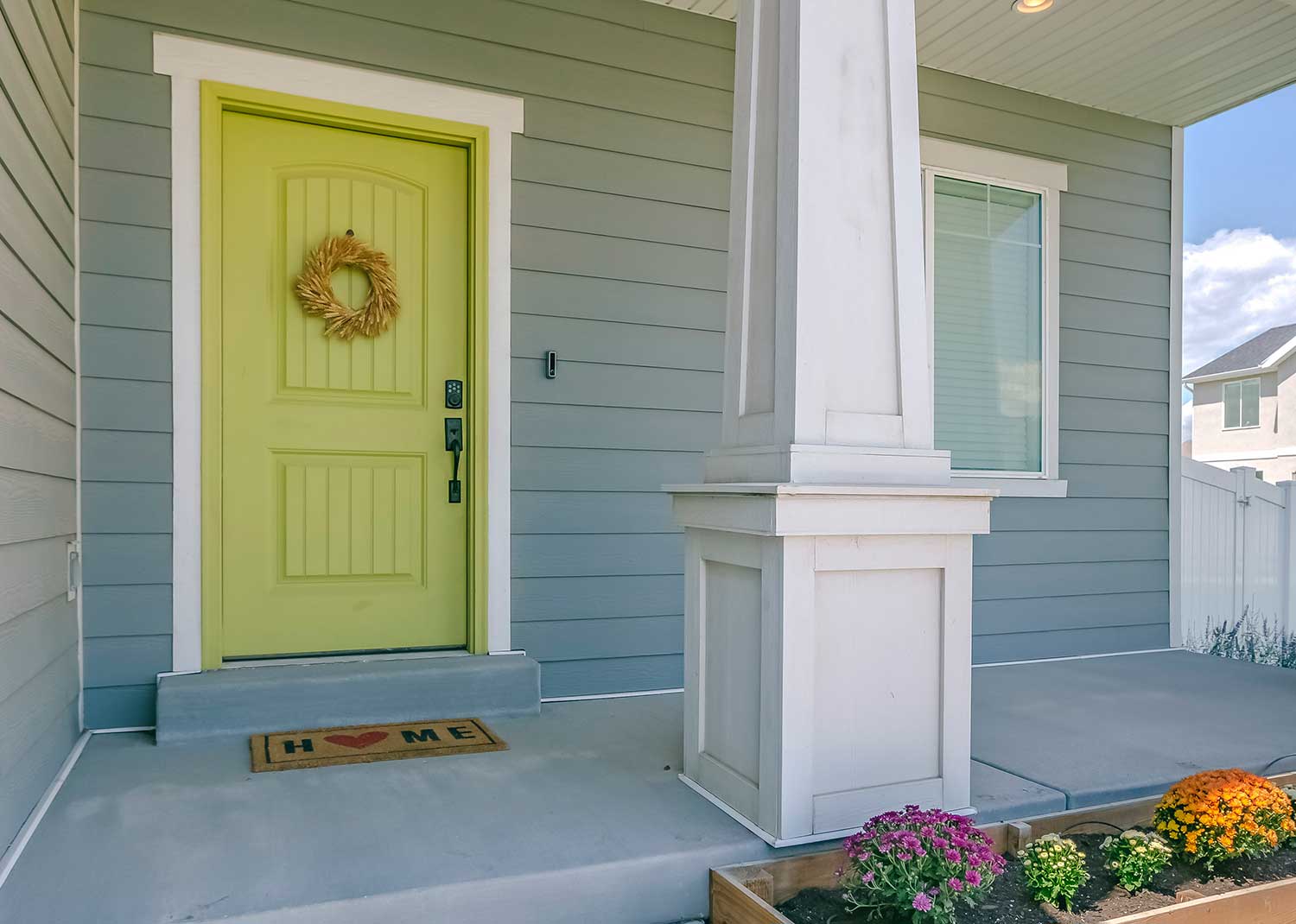 Home with green door, porch and flowers