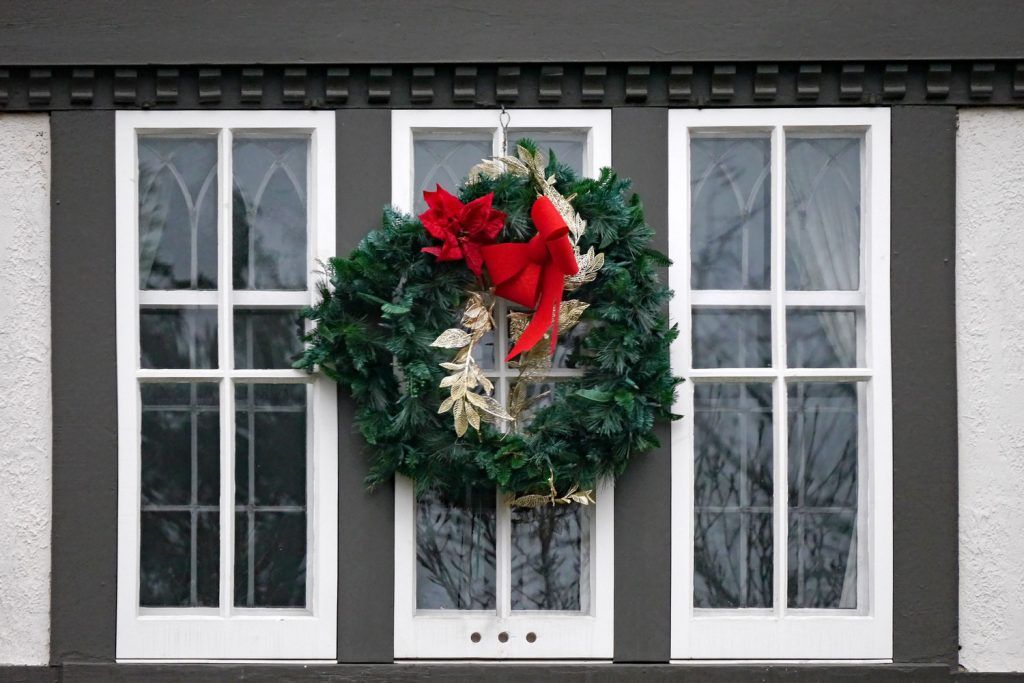 White casement windows with a Christmas wreath hanged on the middle
