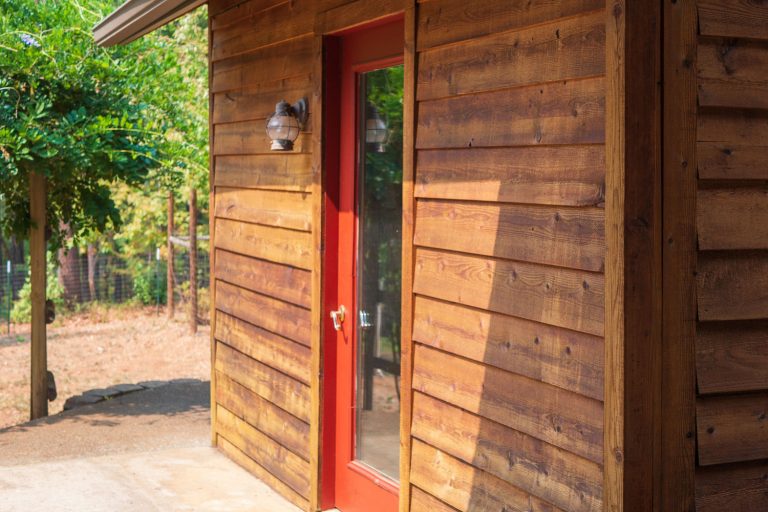 cedar sided house with red door, How Often Should You Stain Cedar Siding?