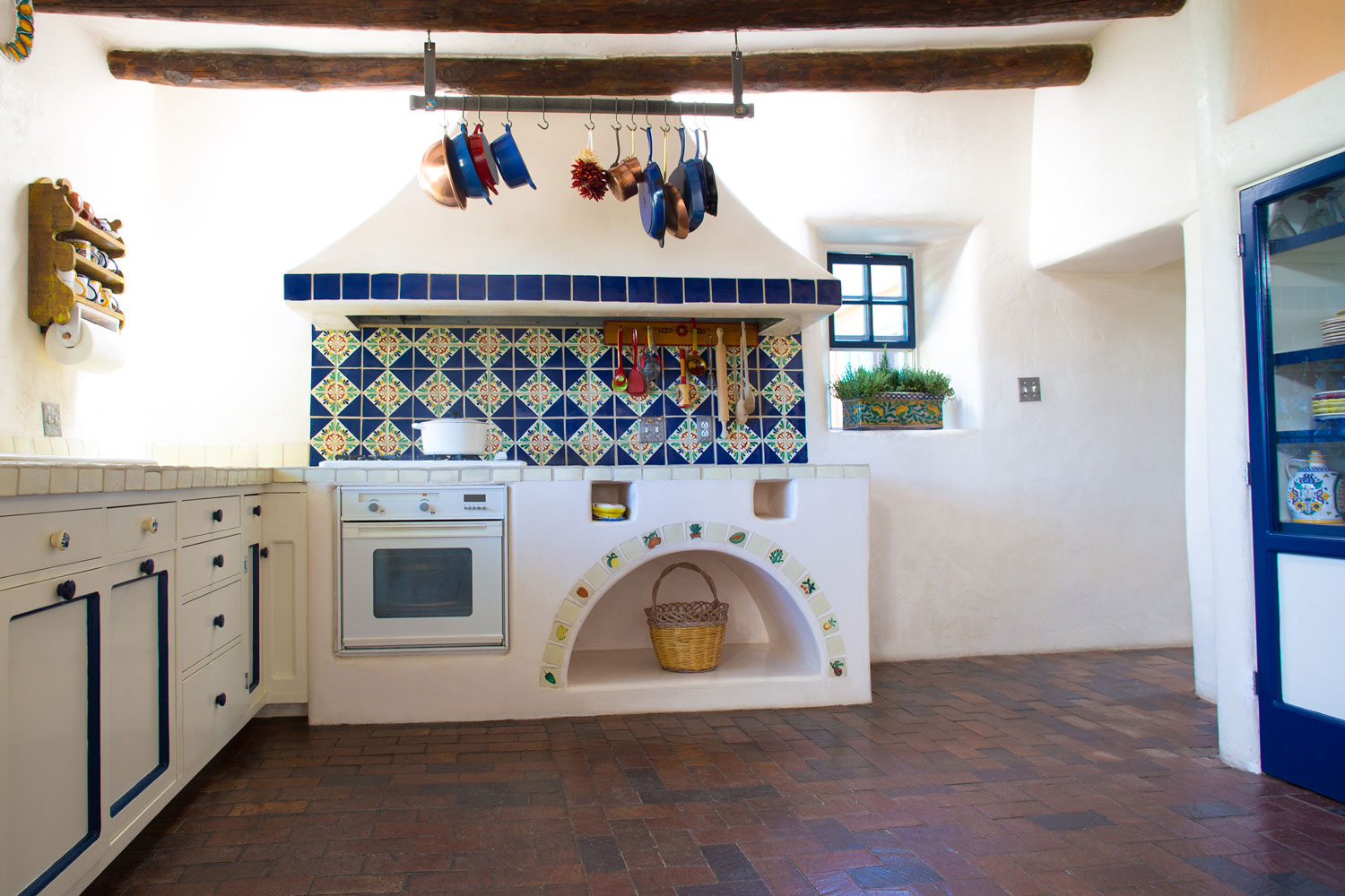 A Mexican inspired kitchen with white walls, blue decorative tiles and dark brown tiles, 15 Awesome Mexican Style Kitchen Ideas