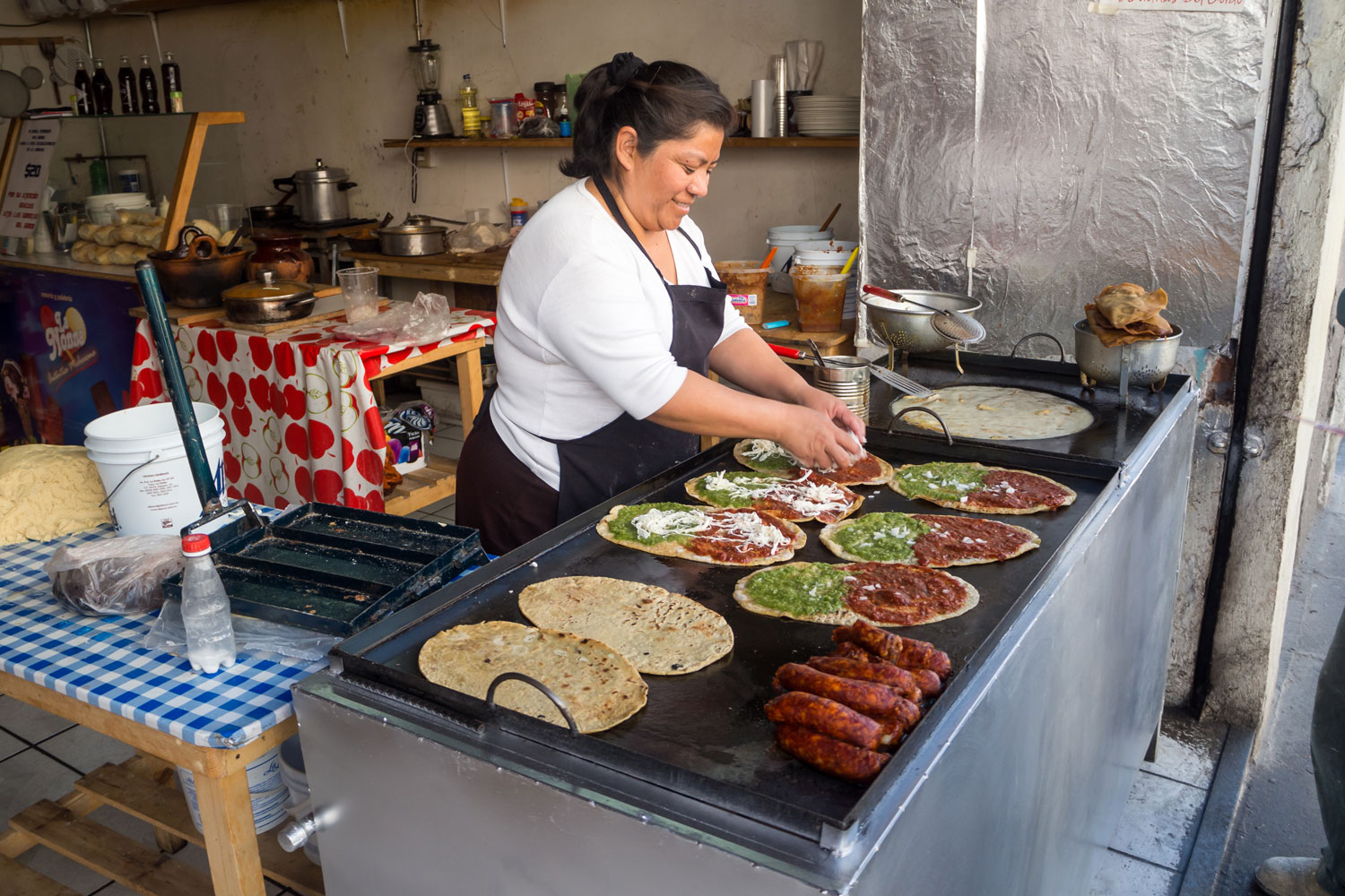A Mexican woman making quesadillas at her kitchen