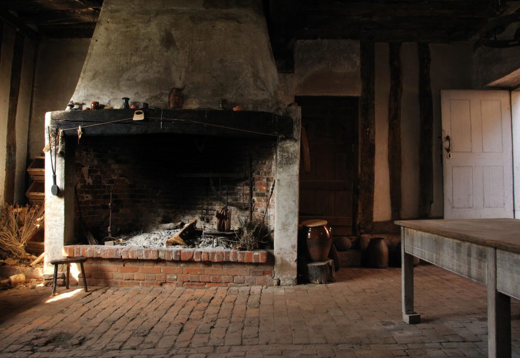 A large old fireplace in an empty bakehouse is complemented