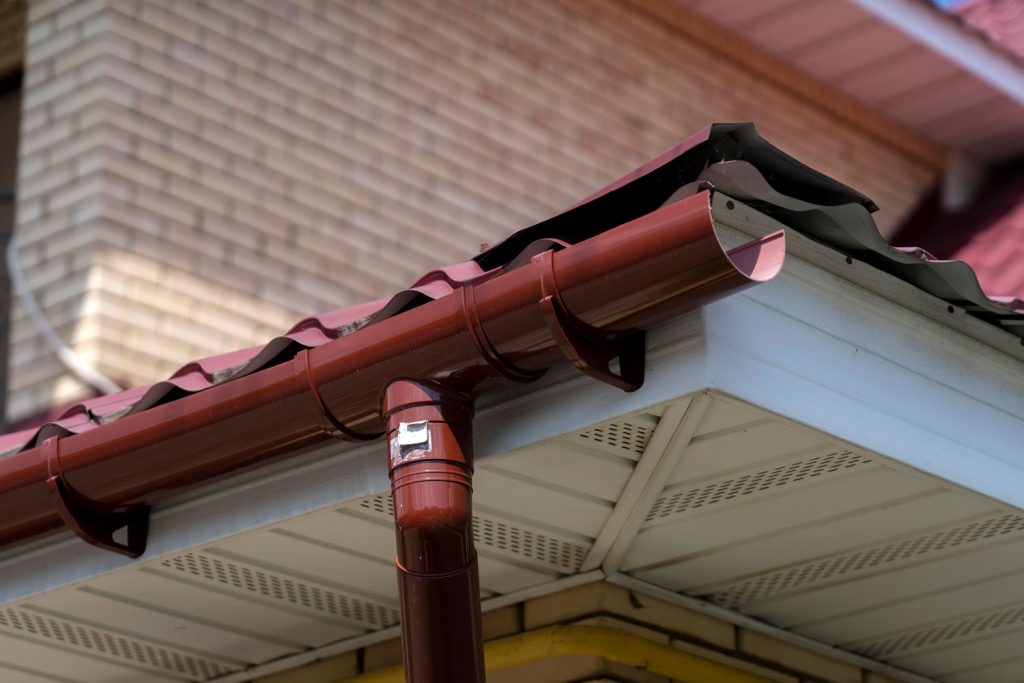 A red coated metal gutter perfectly install in the fascia board