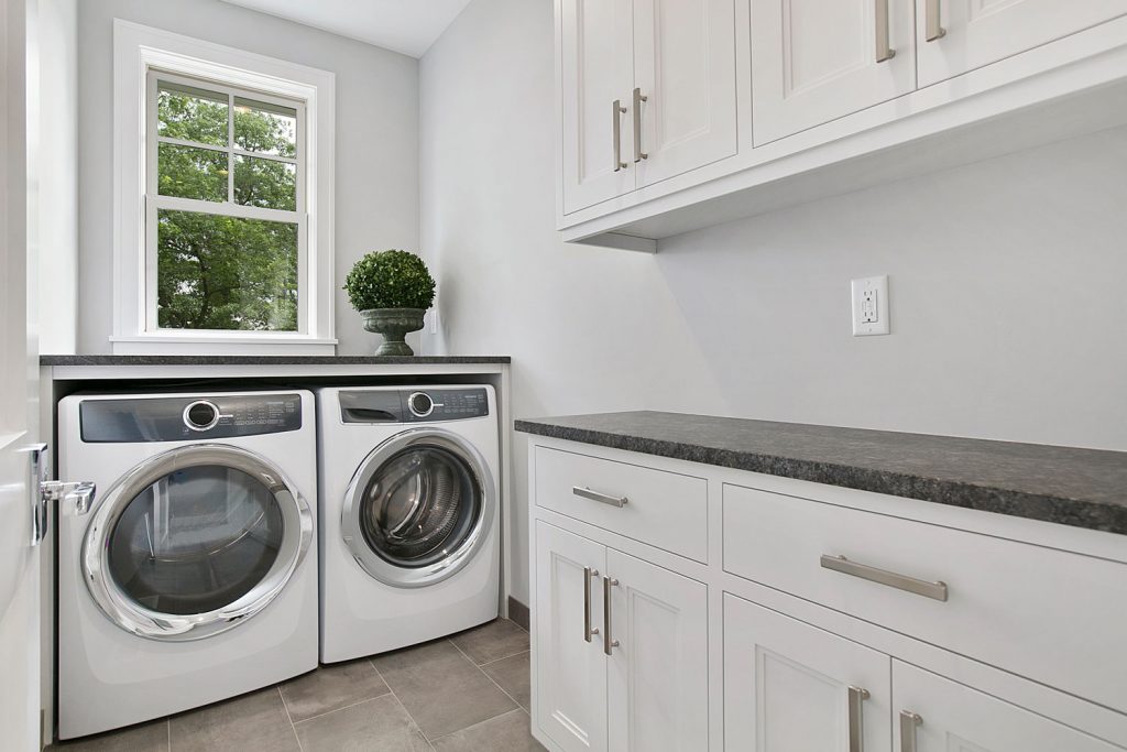 A white inspired laundry room next to the kitchen
